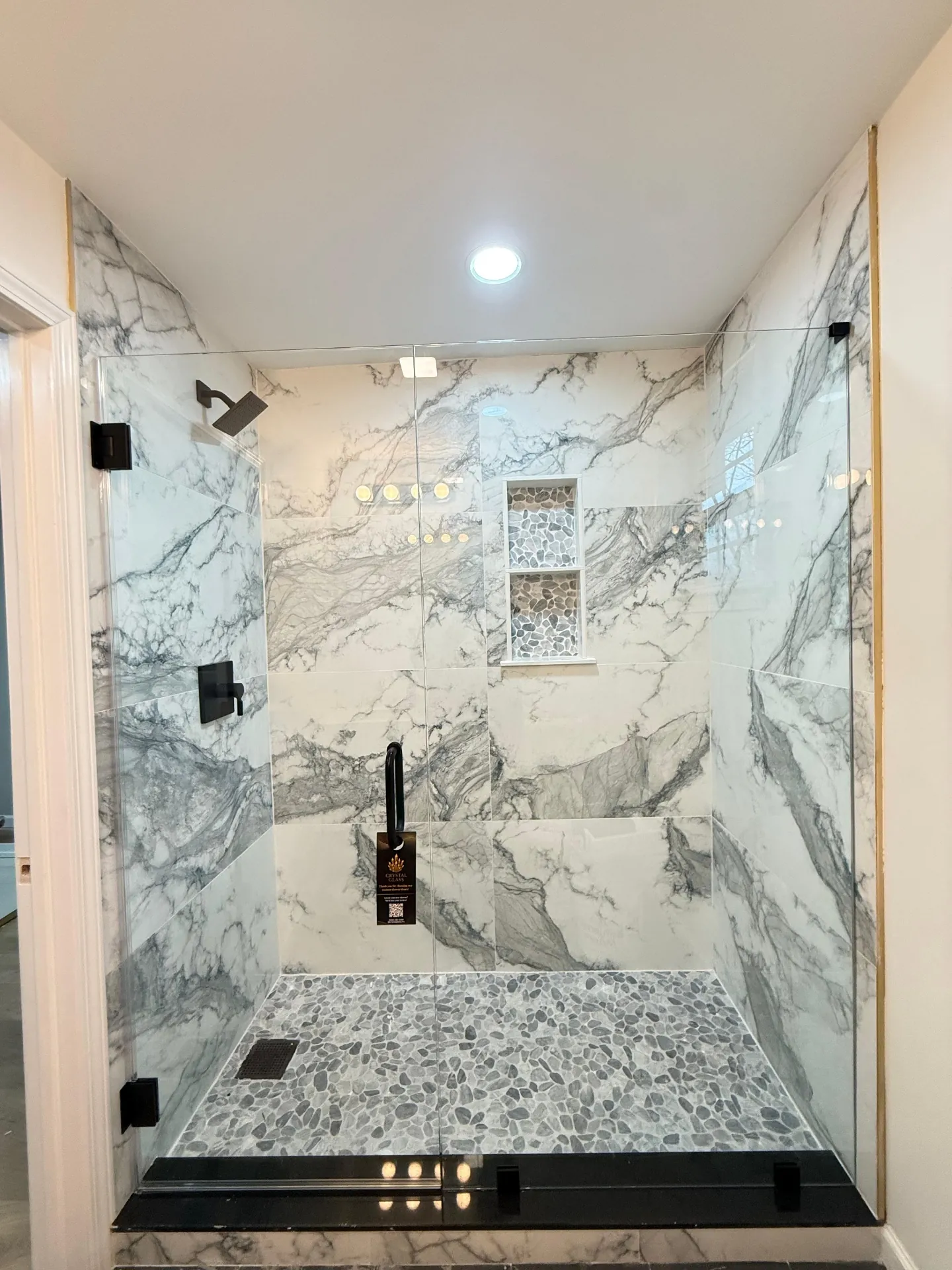 Marble walk-in shower with black hardware